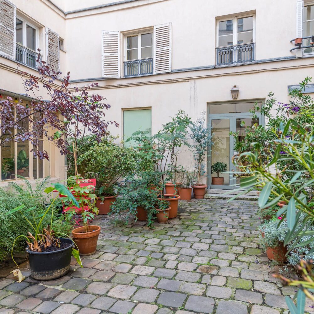 cour arborée de l'hotel particulier du marais à Paris 3. Vente de l'apparetement par l'agence immobilière 21JUIN