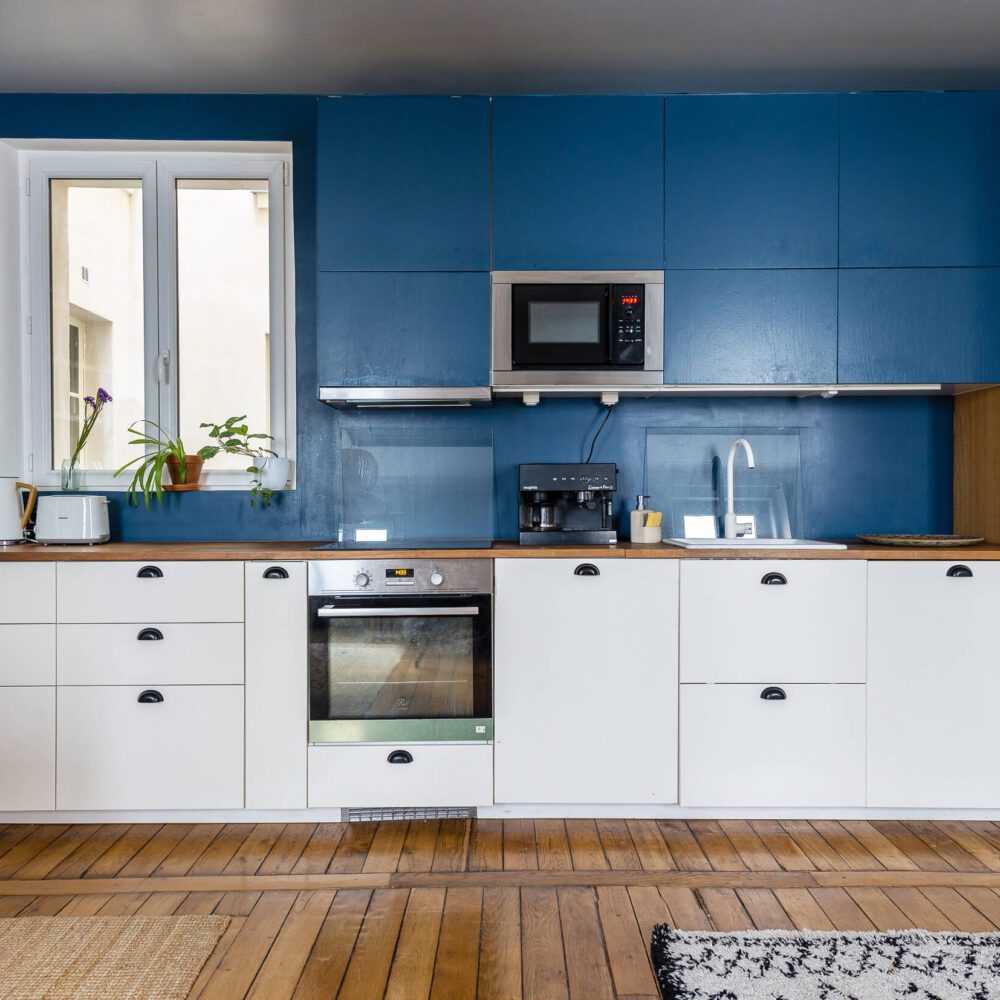 la cuisine ouverte sur le salon et la salle à manger. Repensée par une architecte d'intérieur lors de la rénovation de l'appartement du canal saint martin à vendre. 21juin.immo