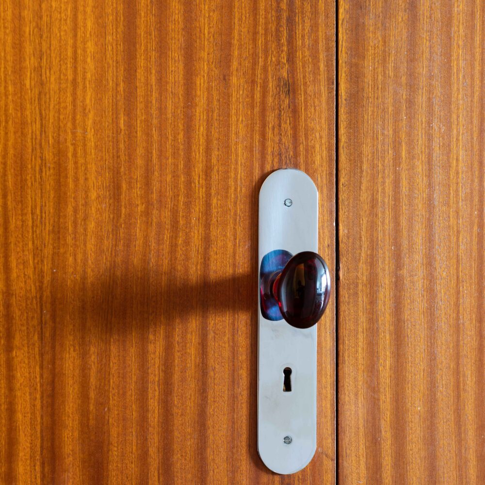 Détail de la poignée de la porte du dressing. Verre couleur grenat. Appartement en vente par l'agence Immobilière 21juin