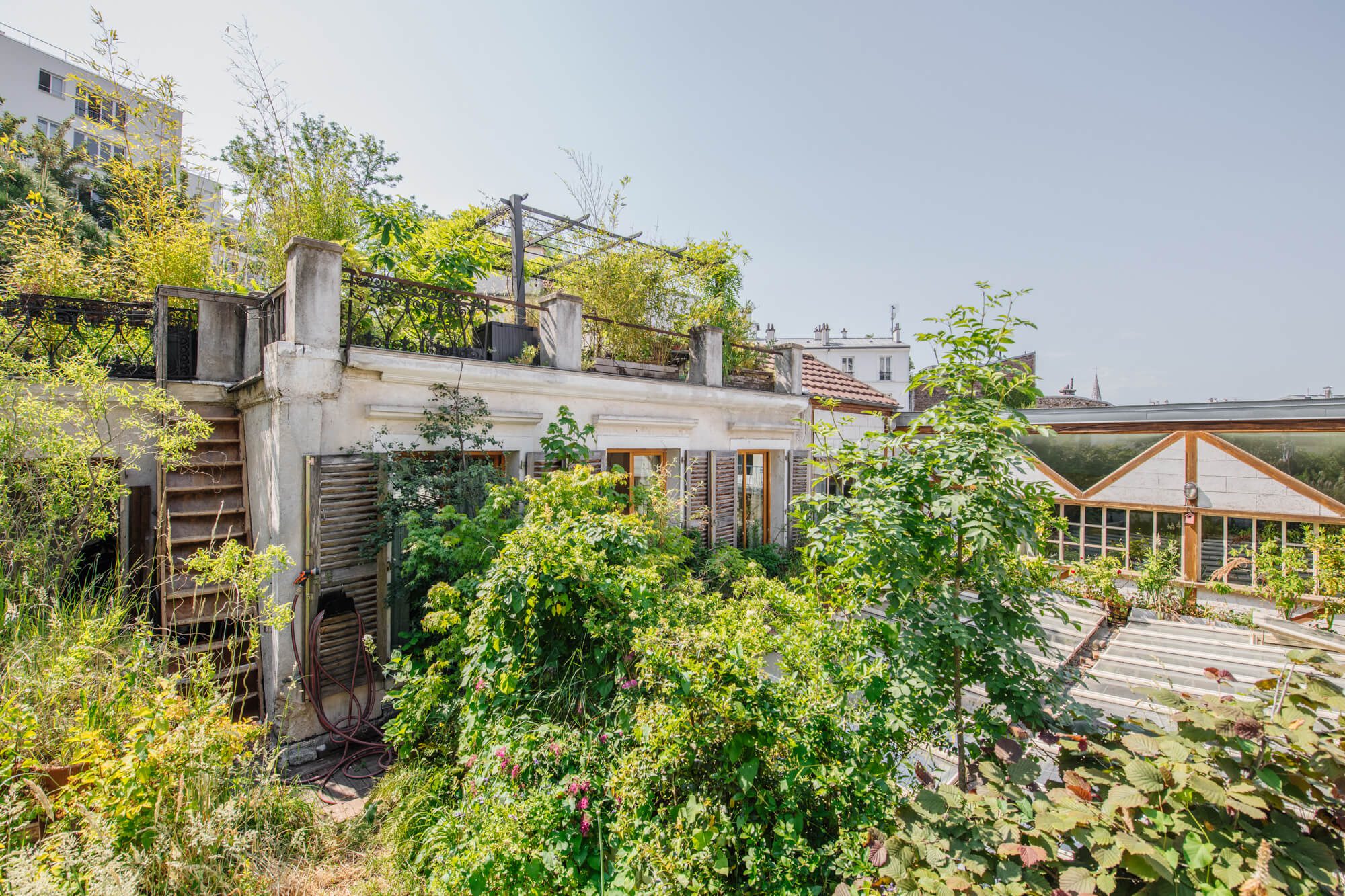 vue de la façade arrière d'une rare maison avec extérieur jardin terrasse en vente à Paris 20. Cachée entre Jourdain et le parc de Belleville cette maison exceptionnelle est en vente par Patrice JUIN, 21juin.immo