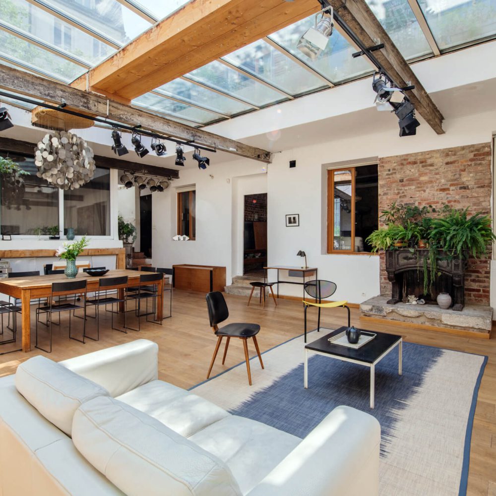 Sous l'immense verrière de cette maison et galerie en vente à Paris 20 dans le quartier du Parc de Belleville et de Jourdain. Un lieu au charme incroyable avec deux extérieurs. Patrice Juin, 21juin.immo